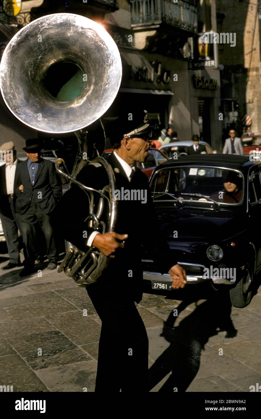 Italian man carrying a Sousaphone (Tuba) in a street in Ferrara, Emilia