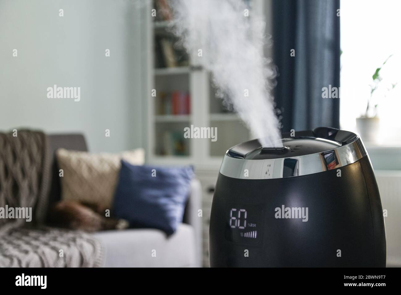 Ultrasonic cool mist humidifier for home on a small table in living room closeup Stock Photo