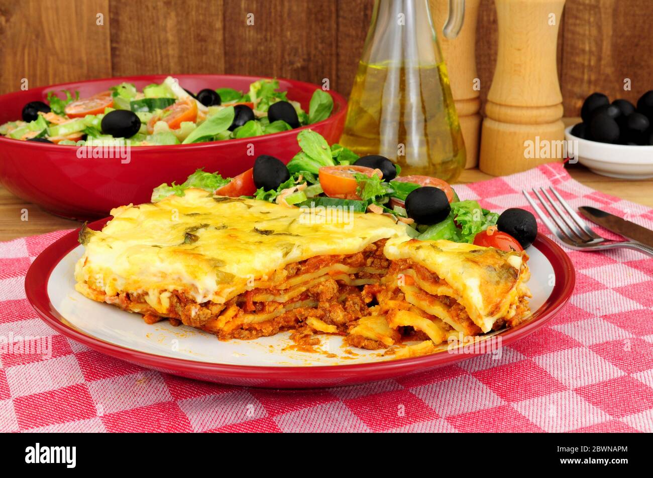 Slow cooked beef and pork ragu lasagne meal with fresh salad and olives