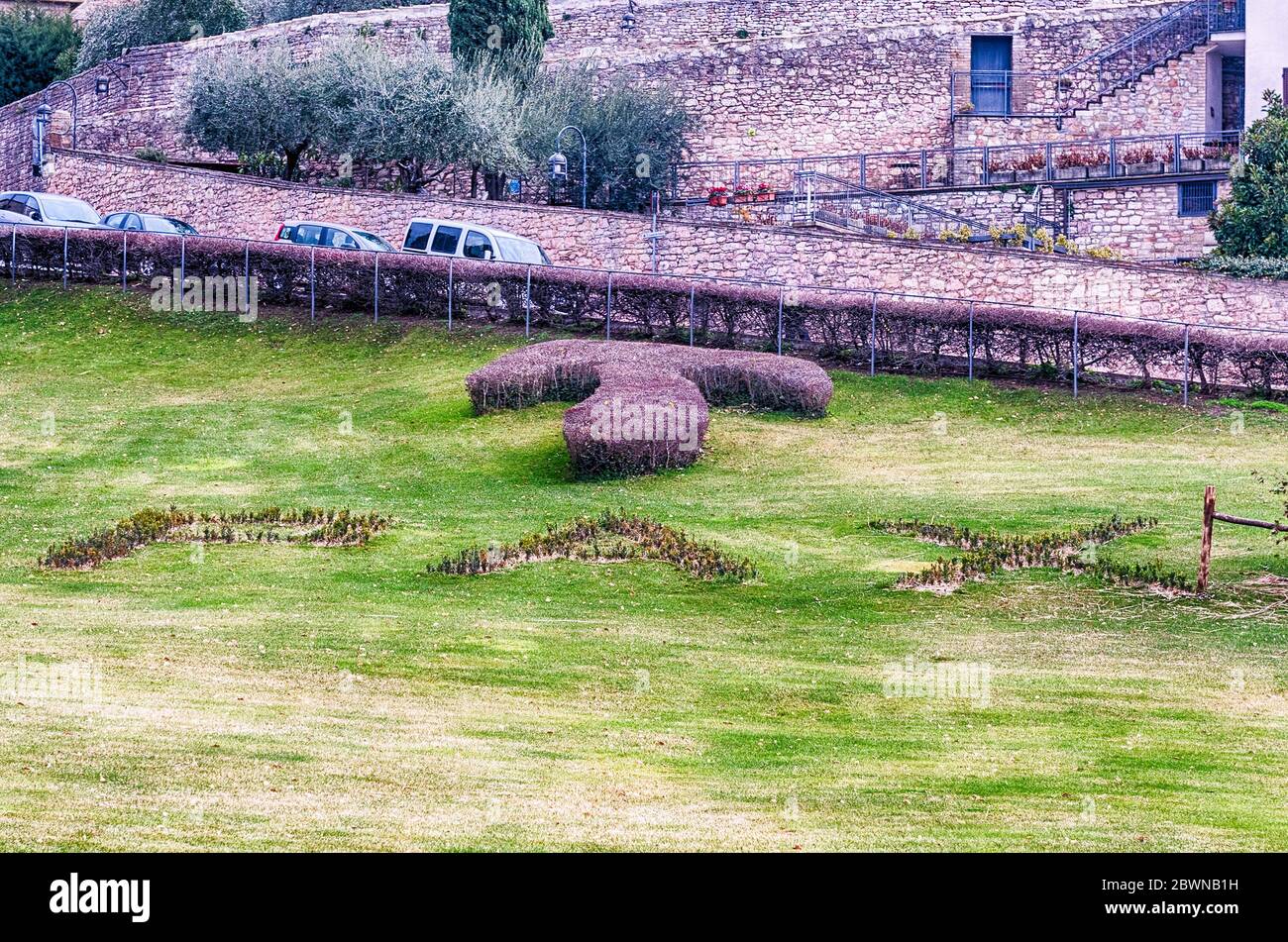 Scenic garden with the symbol of Tau and the word Pax (Translation: 'Peace') written in the grass, outside the Basilica of Saint Francis of Assisi, It Stock Photo