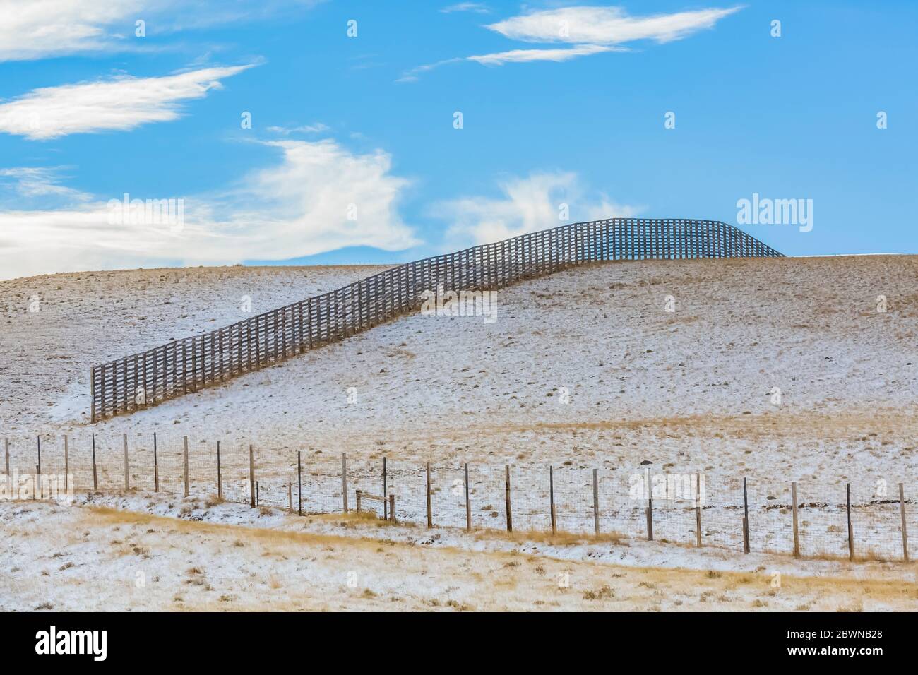 Snow fences placed to catch drifting snow and keep it off Interstate 80 in Wyoming, USA Stock Photo