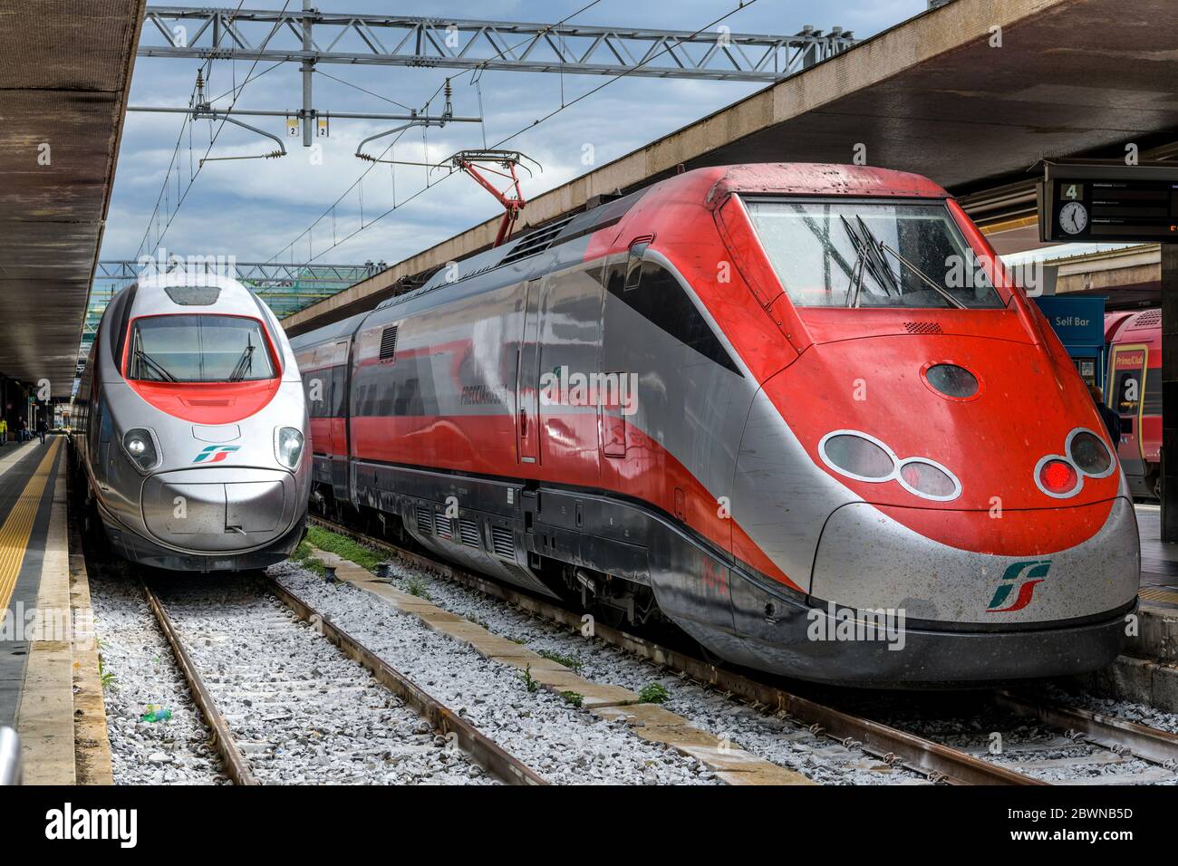 High-Speed Trains - A silver Frecciargento ETR 600 of Trenitalia, arriving at platform, alongside of a parked red Frecciaros ETR 500, in Rome Termini. Stock Photo