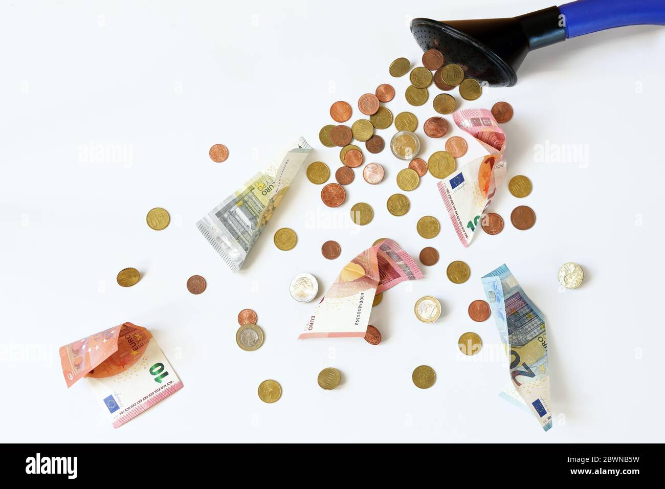 Euro coins and banknotes flow out of a watering can, financial principle to dump money at random, subsidies and grants that are distributed too thinly Stock Photo