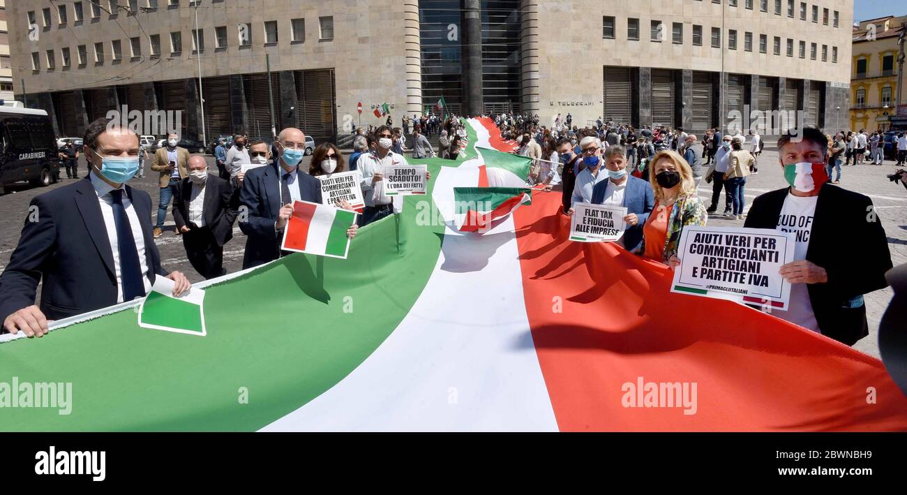 People wearing protective mask hold signs writing 'time out', 'real aid for dealers, profassionals and artisans' and 'flat tax and business confidence' next to a giant banner in the colors of the Italian flag during the Lega per Salvini and FDI ( Fratelli d'Italia) Parties protest against the European Union's aid plans for the countries most affected by the Covid-19 and against Italian Government plan to restart the economy. Stock Photo