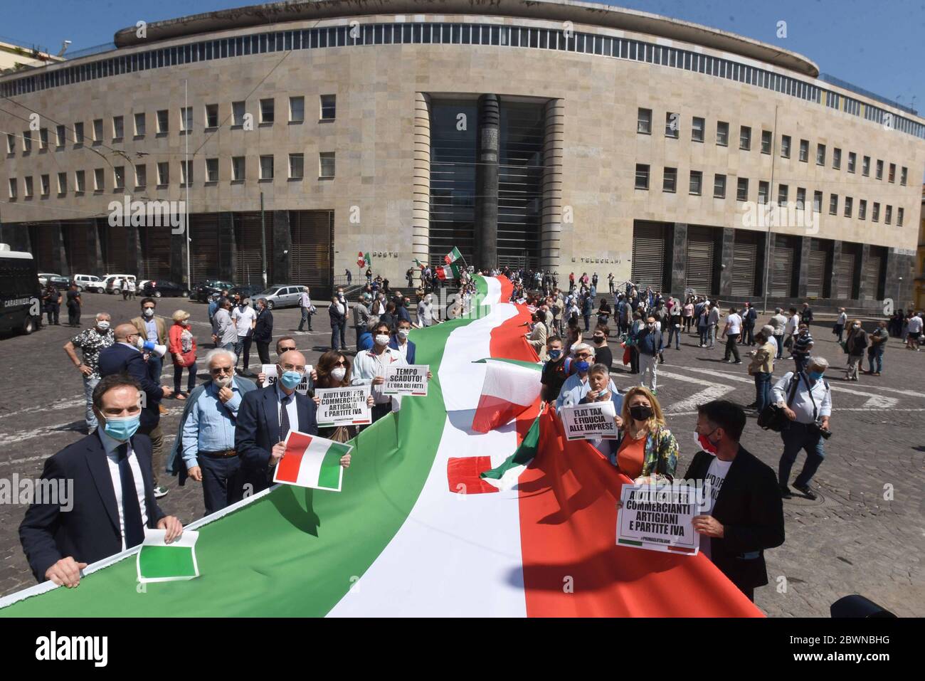 People wearing protective mask hold signs writing 'time out', 'real aid for dealers, profassionals and artisans' and 'flat tax and business confidence' next to a giant banner in the colors of the Italian flag during the Lega per Salvini and FDI ( Fratelli d'Italia) Parties protest against the European Union's aid plans for the countries most affected by the Covid-19 and against Italian Government plan to restart the economy. Stock Photo