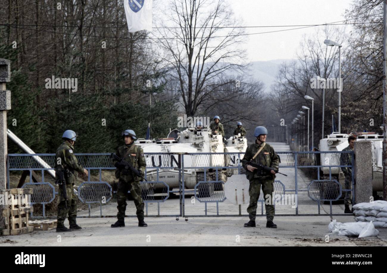 7th March 1994 During the war in Bosnia: Swedish soldiers of Nordbat 2 stand guard beneath a Bosnian flag at the gates to Tuzla Airport. Stock Photo