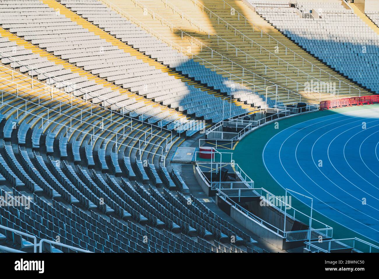Rows of empty seats around a race track of a large stadium on sunny day ...
