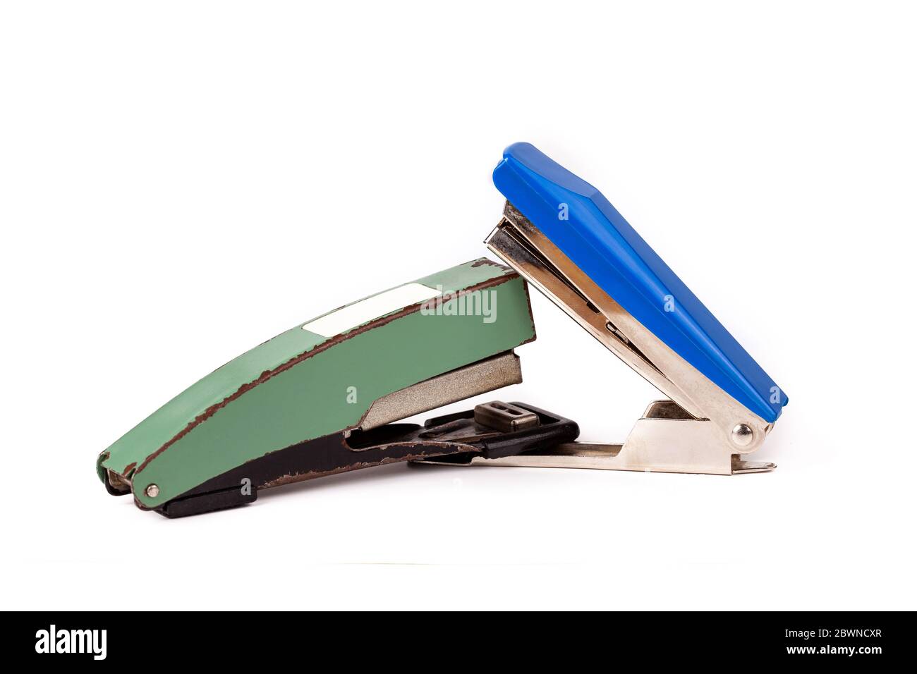 Two staplers fighting, stapling, biting each other. New vs old fight, new winning Office war, desk accessories duel, brawl, conflict funny abstract Stock Photo