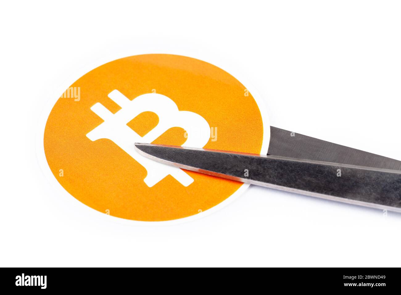 Bitcoin symbol, logo being cut in two with scissors, white background Halving, cutting price, going downwards, bearish crypto currency trend, BTC Stock Photo