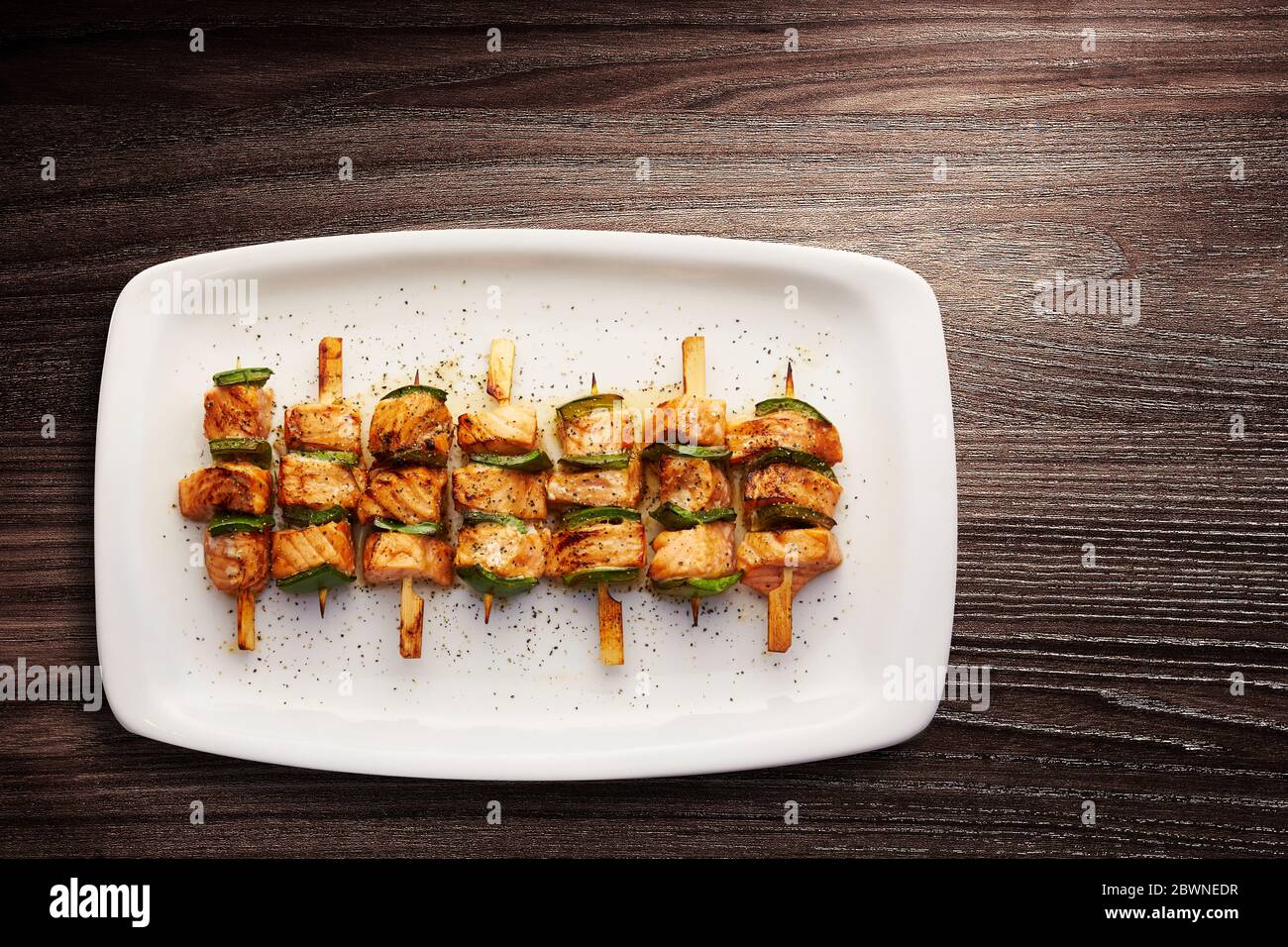 Directly above shot of Teriyaki glazed salmon skewers with green peppers served in a plate Stock Photo