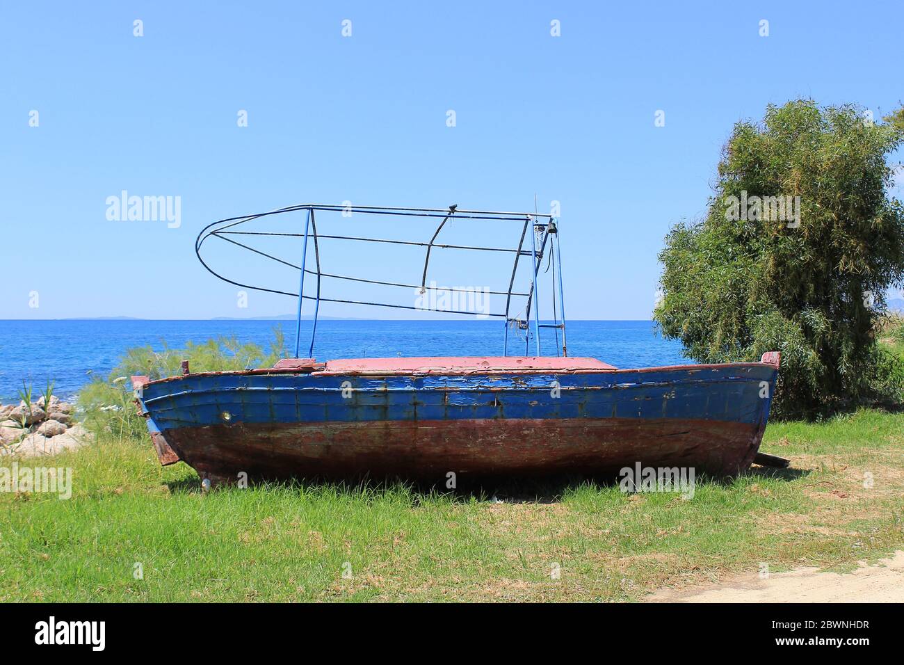 Old abandoned wooden fishing boat on the coast. Background view of the ...