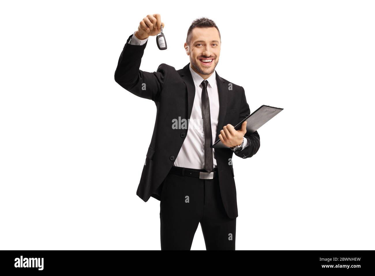 Smiling man in a suit showing a car key isolated on white background Stock Photo