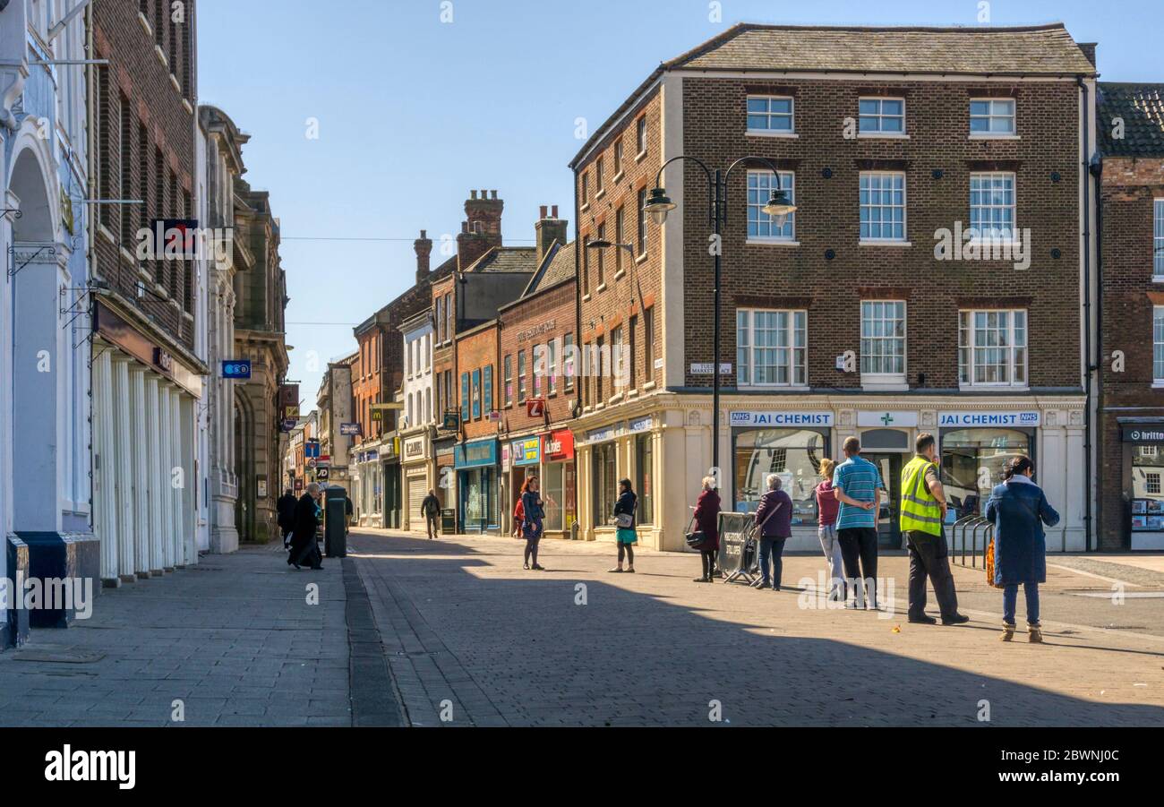 People queueing suitably socially distanced to enter a branch of Lloyds Bank in King's Lynn during the 2020 COVID-19 coronavirus pandemic. Stock Photo