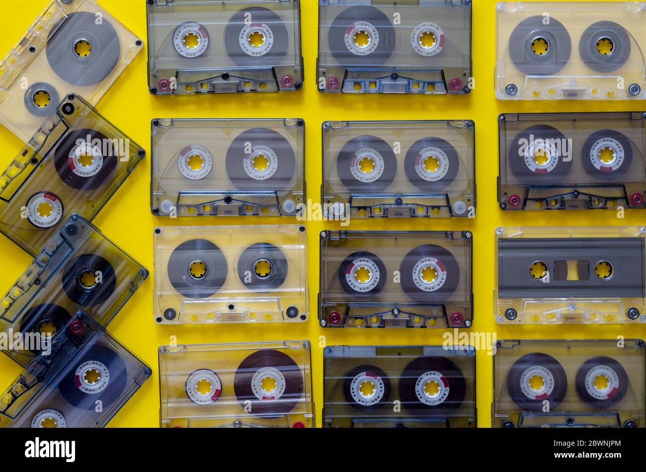 Vintage audio cassettes on a yellow background. 90s music on audio cassettes. Many audio tapes