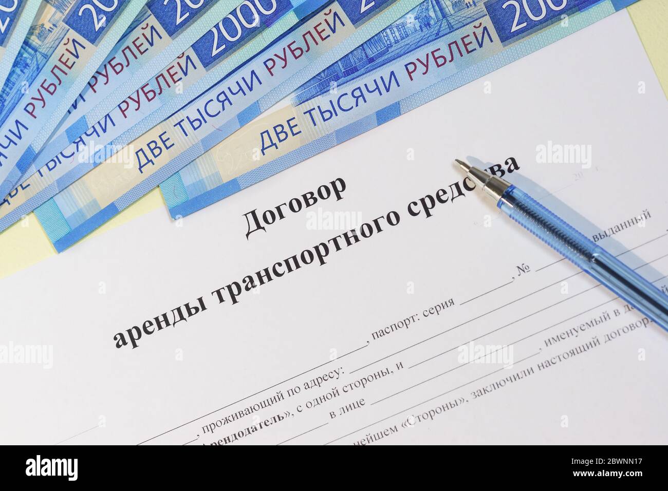Registration of documents and payment. Russian text 'vehicle rental agreement', rubles and pen Stock Photo