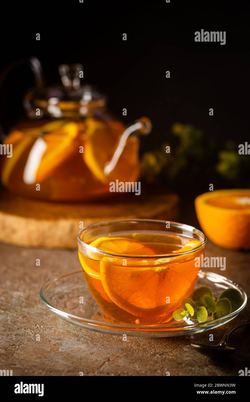 Glass teapot with hot citrus tea from oranges, lemons and limes