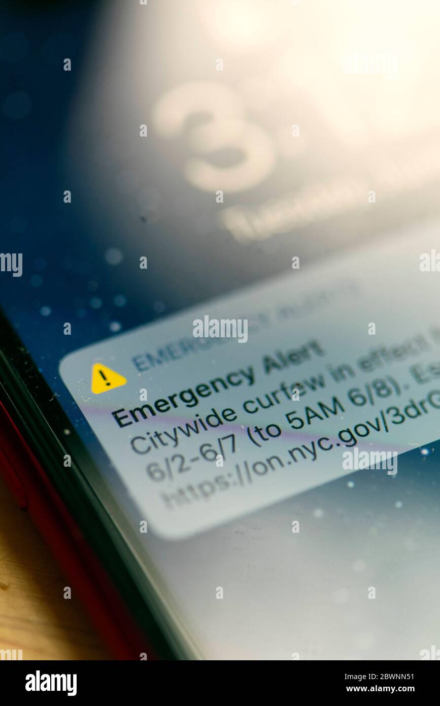 Electronic alert from New York City authorities announcing 8pm - 5am citywide curfew from June 2nd to 7th 2020, displayed on a phone in NYC, NY, USA. Stock Photo