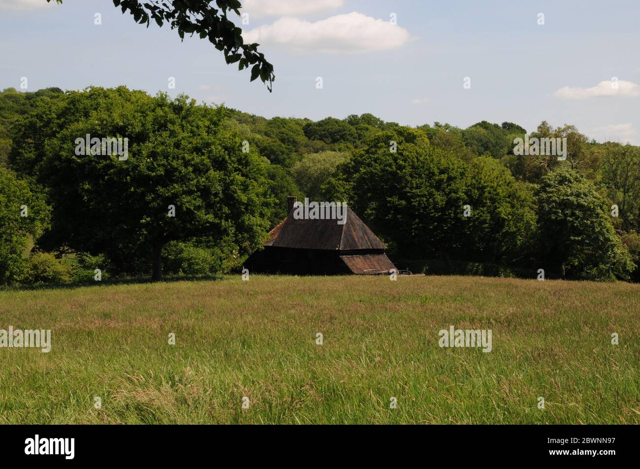 A barn nestles into the wooded landscape near the village of Mayfield in the High Weald of East Sussex. Stock Photo