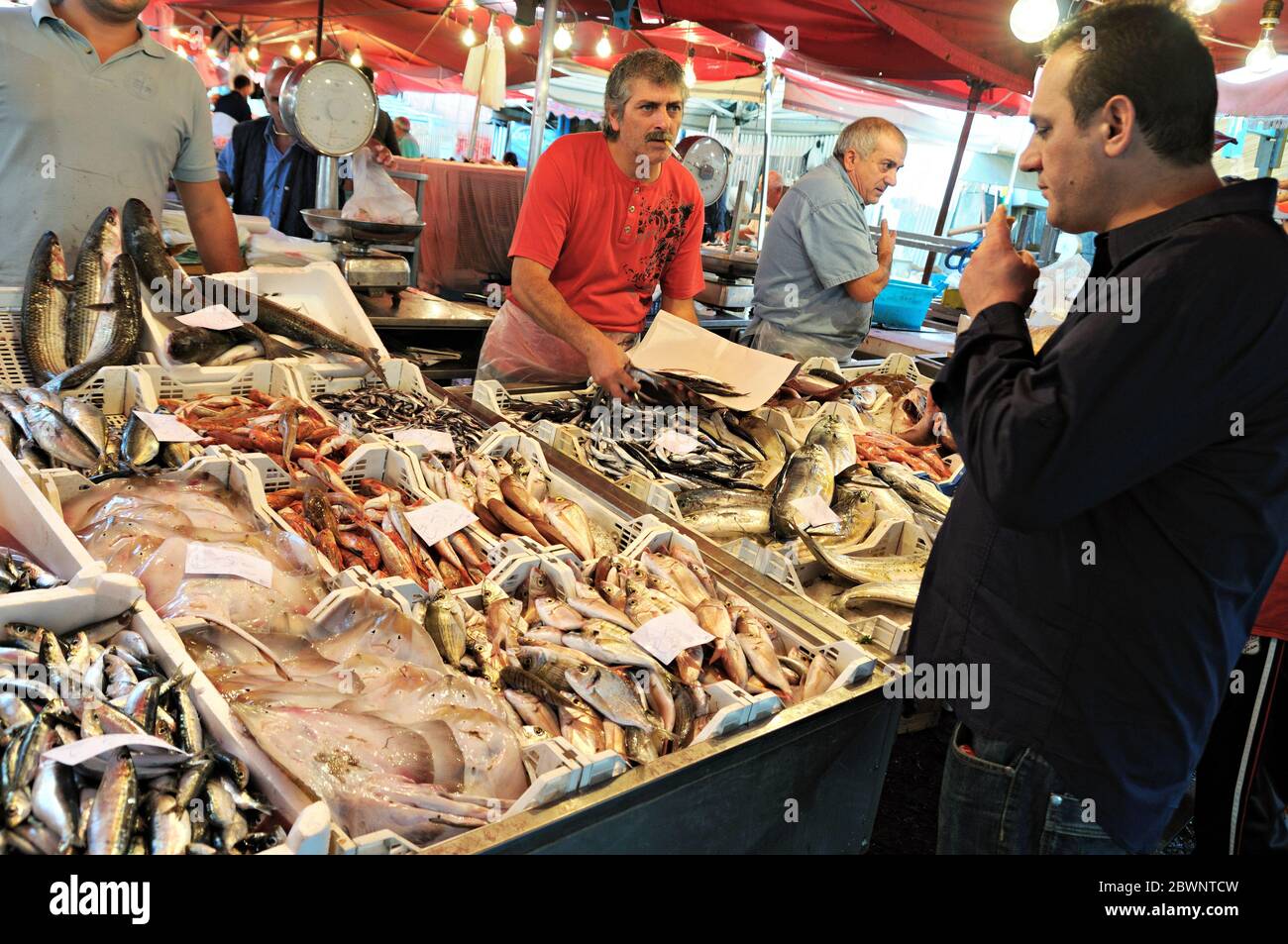 Customer and fishmongers at the Pescheria (fish market) in Catania, Sicily, Italy Stock Photo