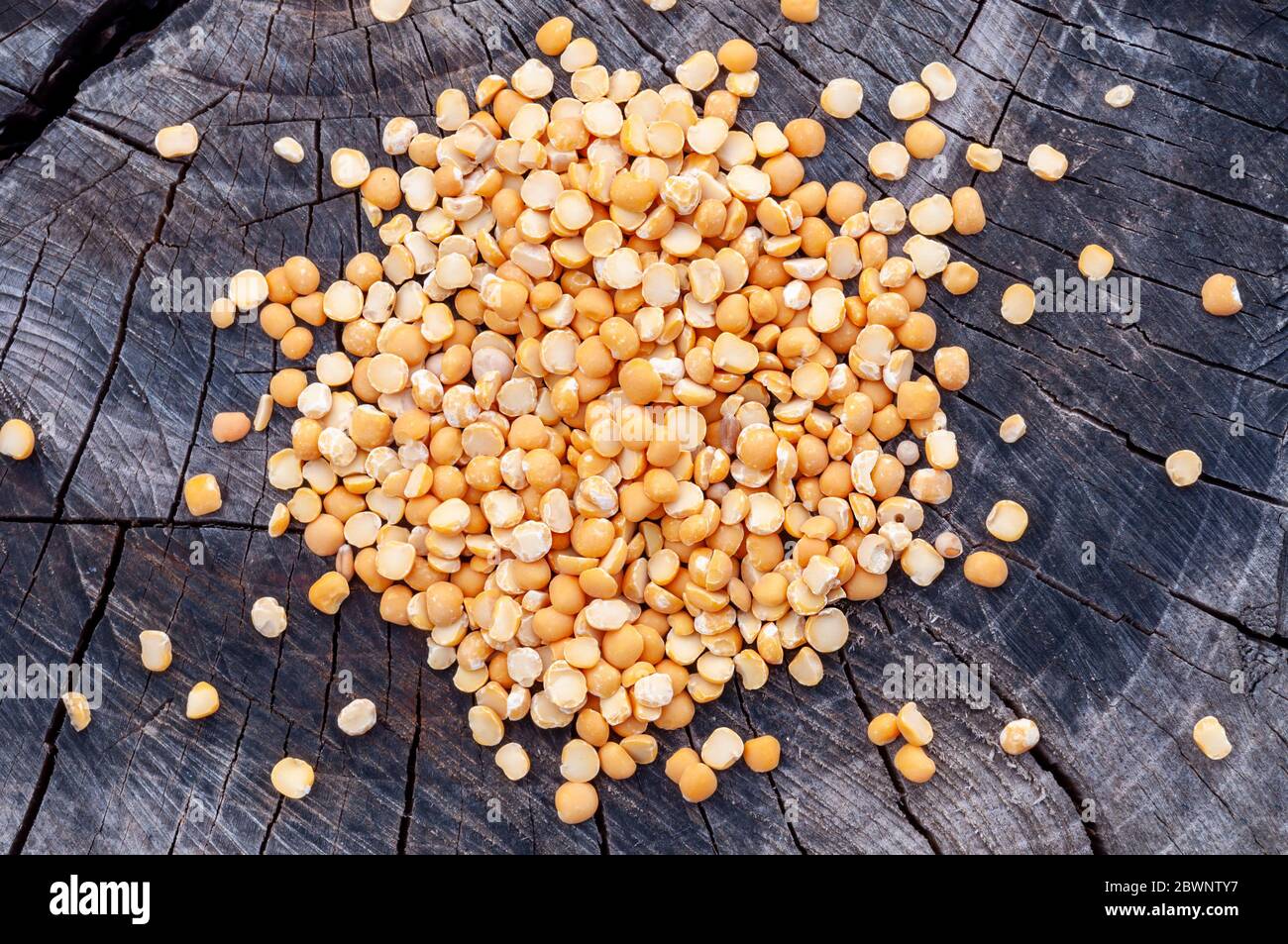 Dry split peas scattered on an old stump Stock Photo