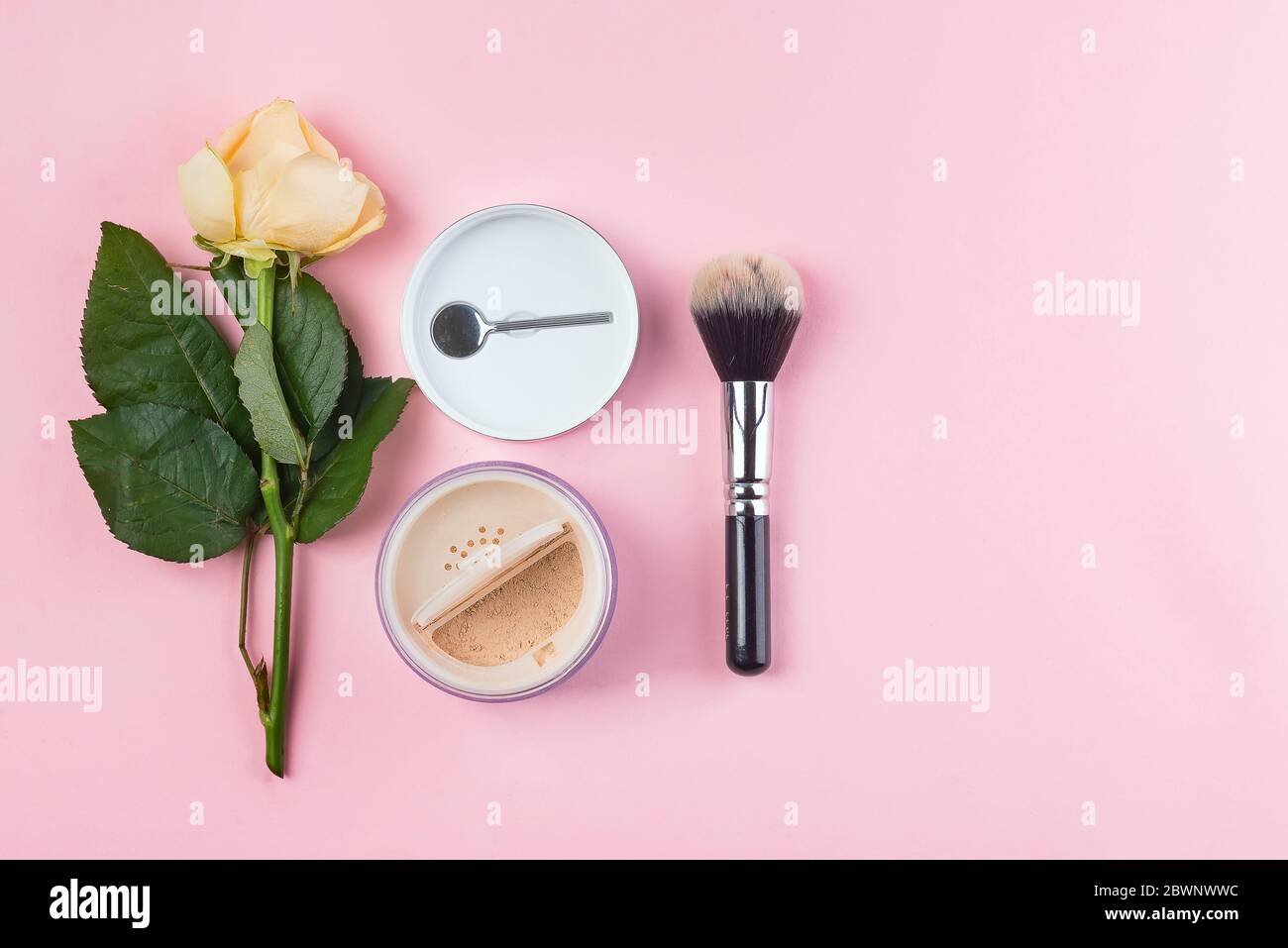 Set of cosmetics powder and brushe with rose on pink background. Makeup Accessories Top view Flat Lay Stock Photo