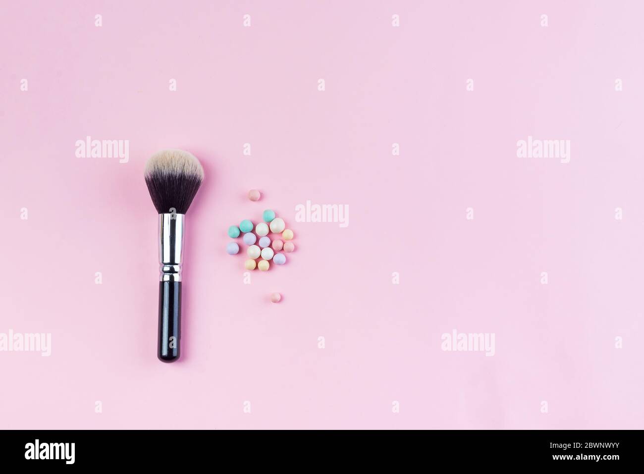 Set of colorful cosmetics powder balls and brushe on pink background. Makeup Accessories Top view Flat Lay Stock Photo