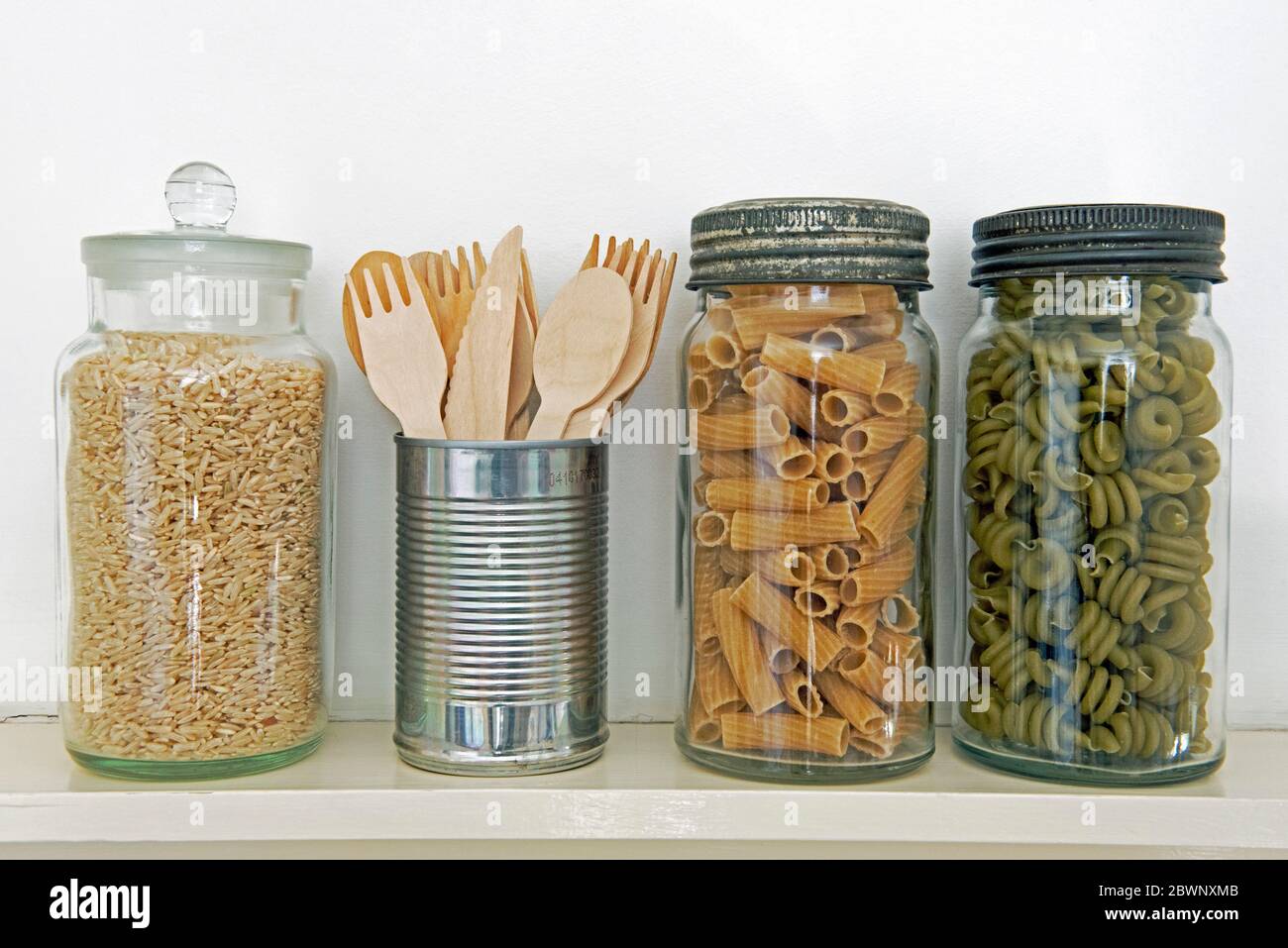 Reusable wooden cutlery stored in recycled tin can on shelf next to