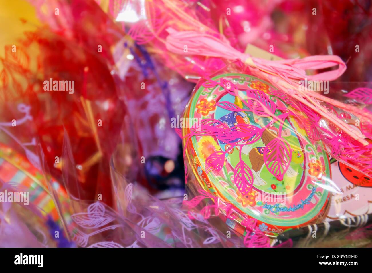 Textured drawing in a small metal oval box of candy with plastic wrap. Stock Photo
