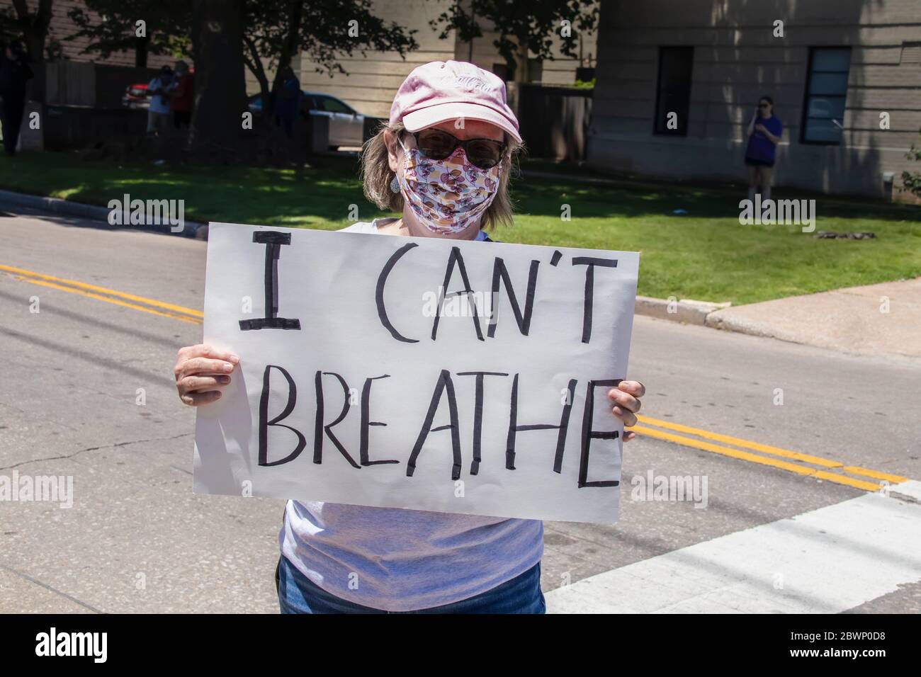 05-30-2020 Tulsa USA Woman in pink ball cap and printed mask holding sign reading I cant breathe standing in middle of road Stock Photo