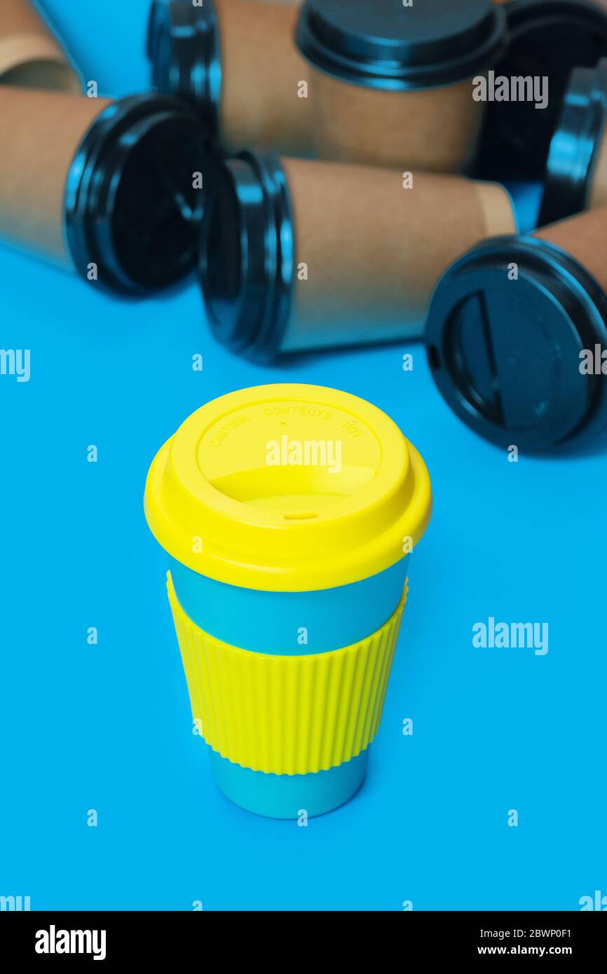 Stylish reusable eco coffee cup and multiple single use cardboard cups Stock Photo