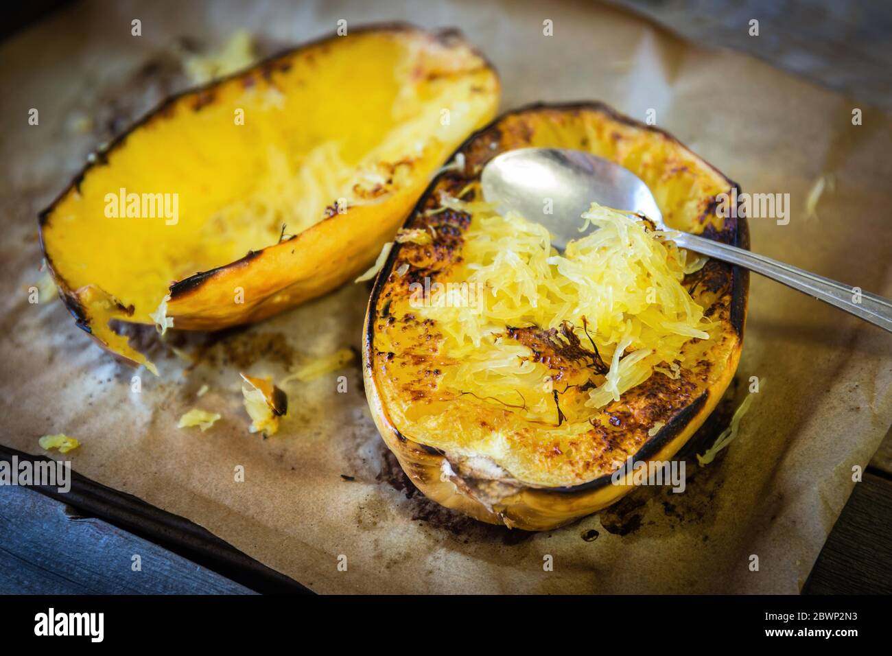 horizontal image of fresh roasted yellow spaghetti squash lying on brown roasting paper in