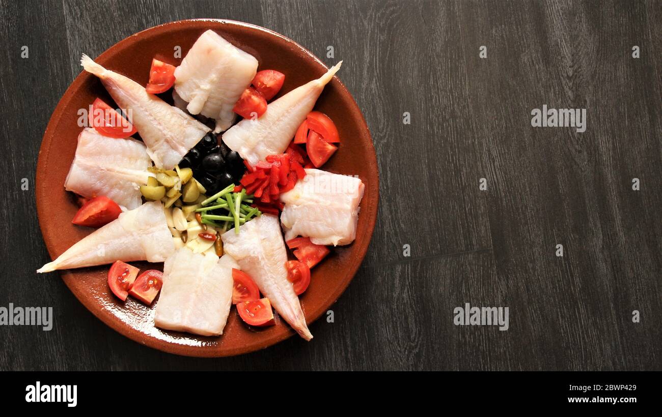 Prepared ingredient monk-fish on pottery dish. photo isolate on black top view copy space Stock Photo