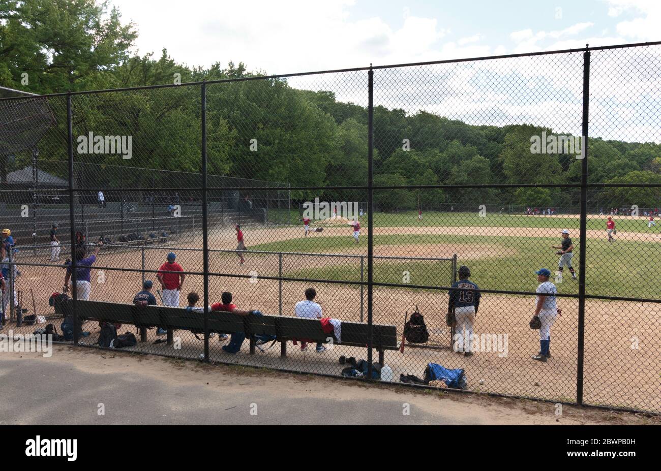 people playing a baseball game in Inwood Hill Park on a Sunday despite group play being prohibited due to the coronavirusor covid-19 pandemic Stock Photo