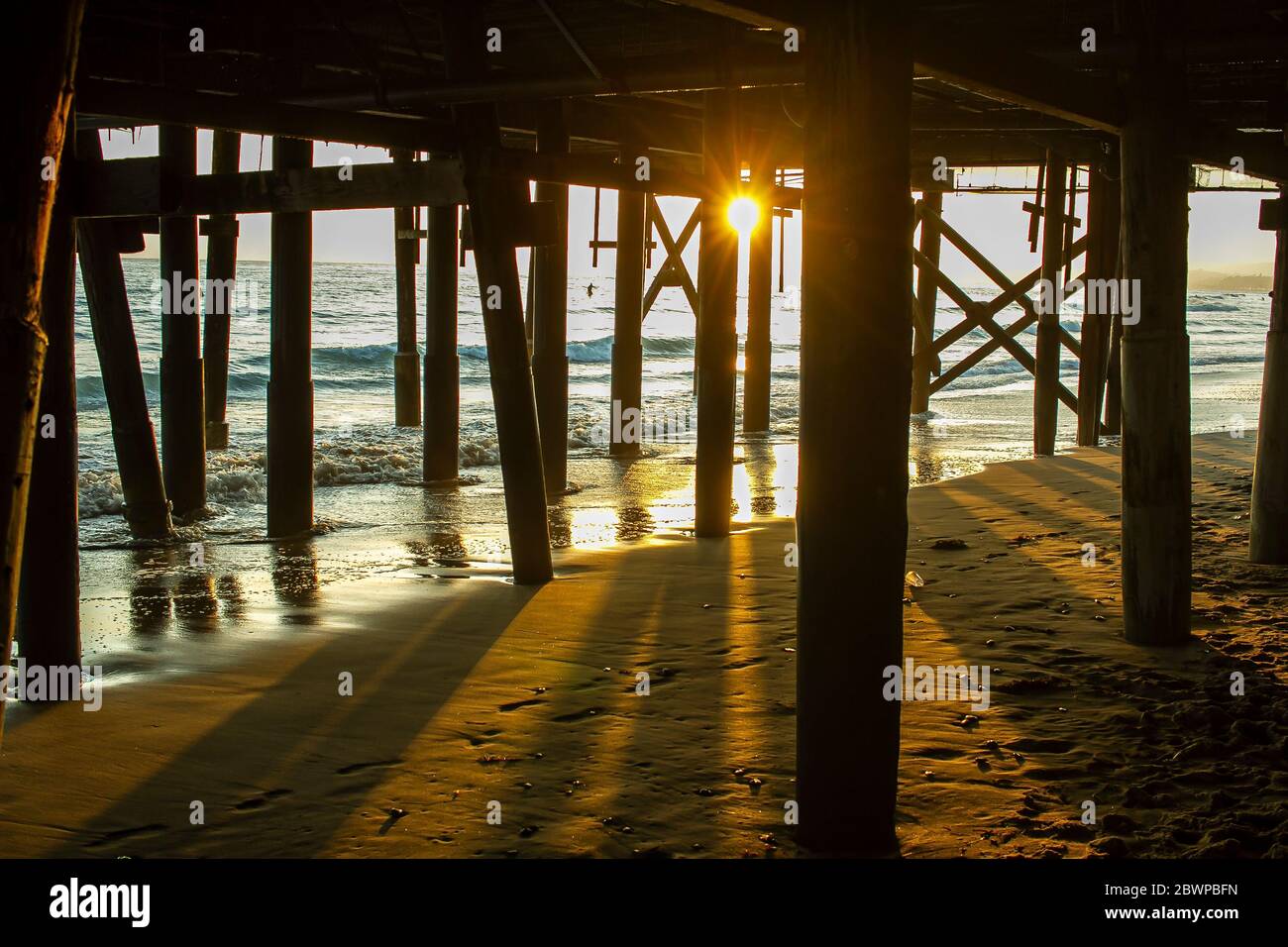 Sunset from under a pier with an etherial look Stock Photo