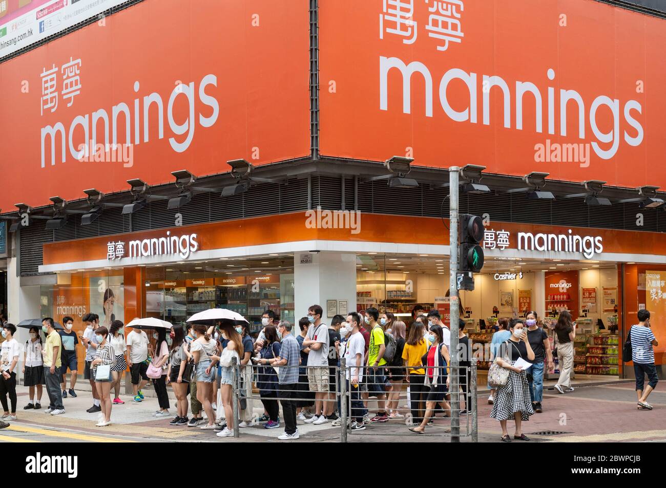 Pedestrians at a traffic light seen in front of personal care branch of