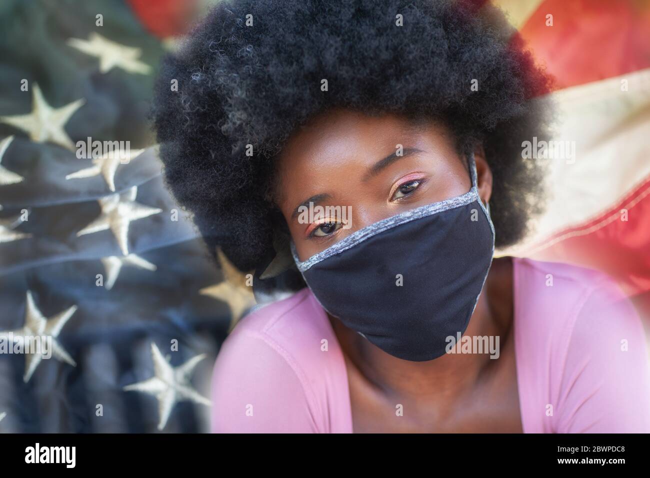 A portrait of a beautiful black girl wearing face masks with the USA flag on the background. Stock Photo