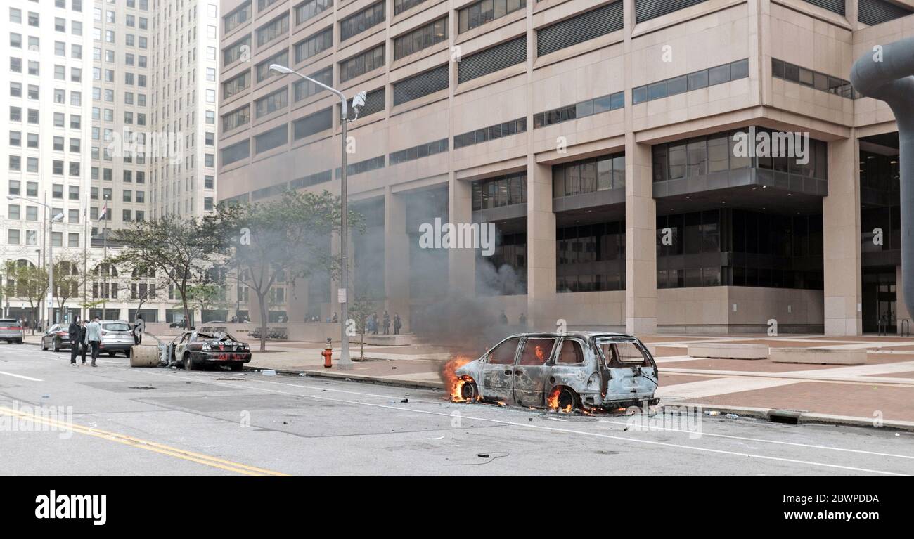A burning car sits on the street outside the Cleveland Justice Center in Cleveland, Ohio, USA as one of many that were vandalized during the May 30, 2020 Black Lives Matter movement gathering.  The Justice Center, home of the Cleveland Police, was vandalized as protesters gathered after a peaceful march and were met with police using tear gas and other heavy-handed tactics to disperse the group. Stock Photo