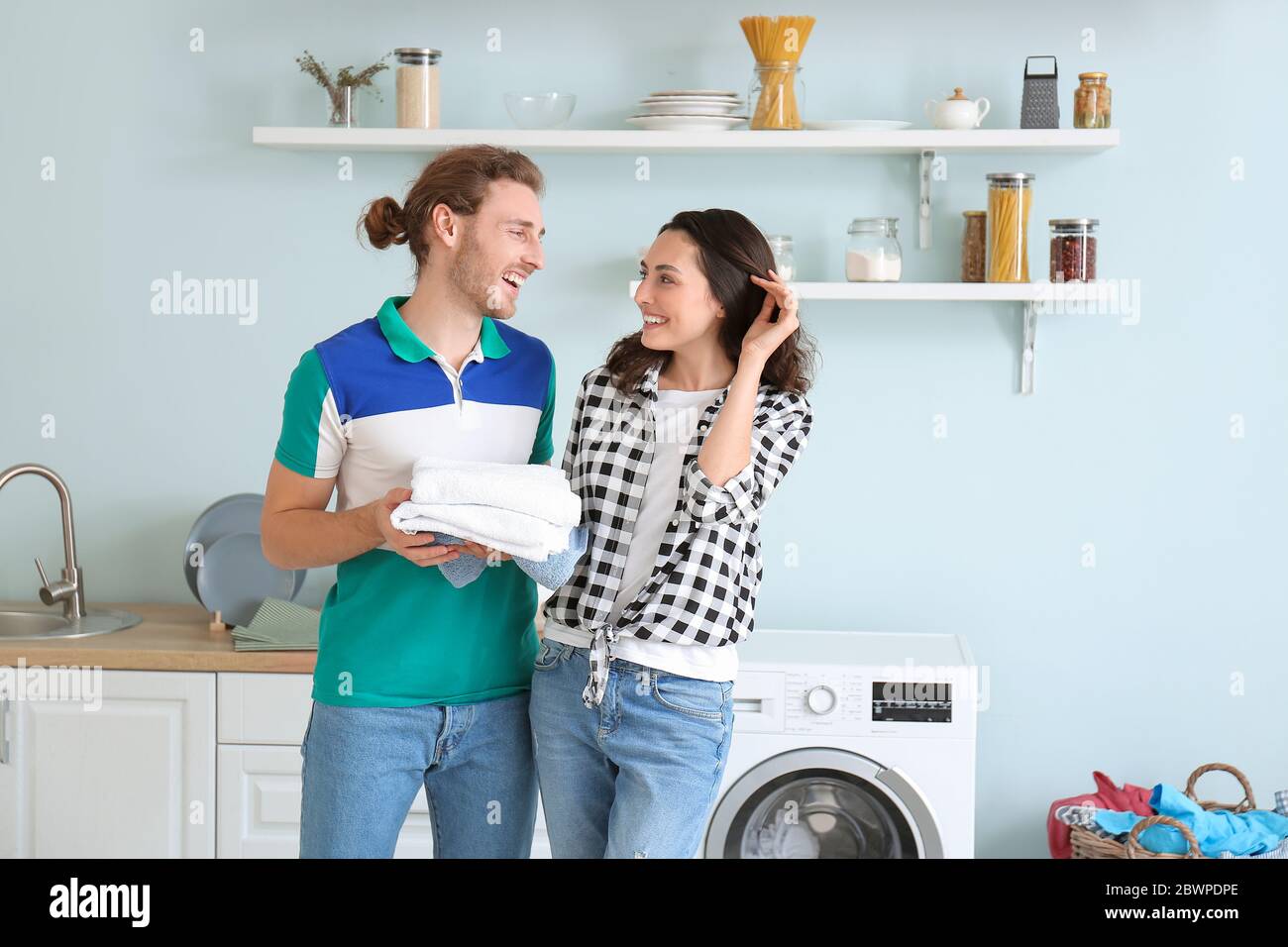Happy young couple doing laundry at home Stock Photo - Alamy