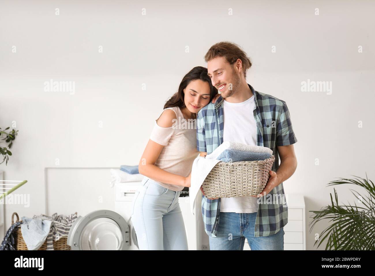 Happy young couple doing laundry at home Stock Photo - Alamy