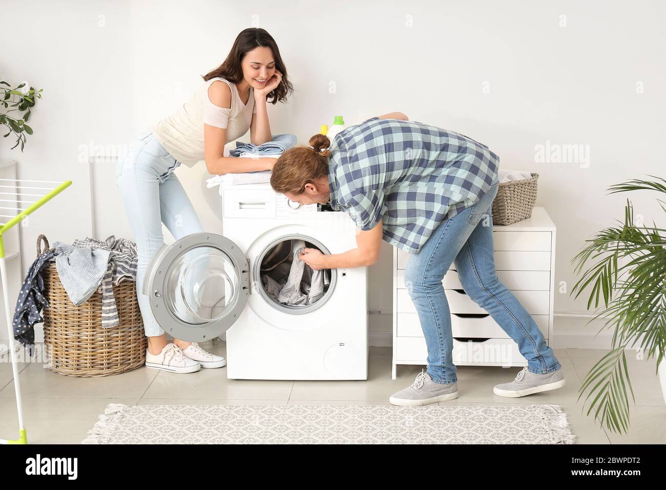 Happy young couple doing laundry at home Stock Photo