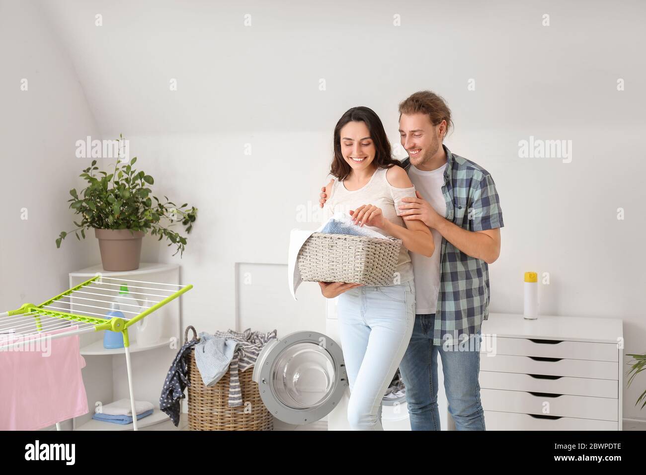 Happy young couple doing laundry at home Stock Photo