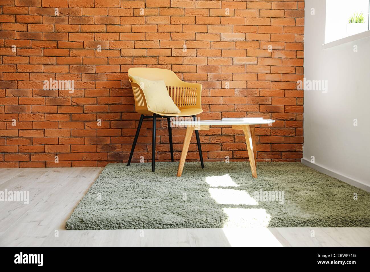 Stylish interior of living room with carpet, chair and table Stock