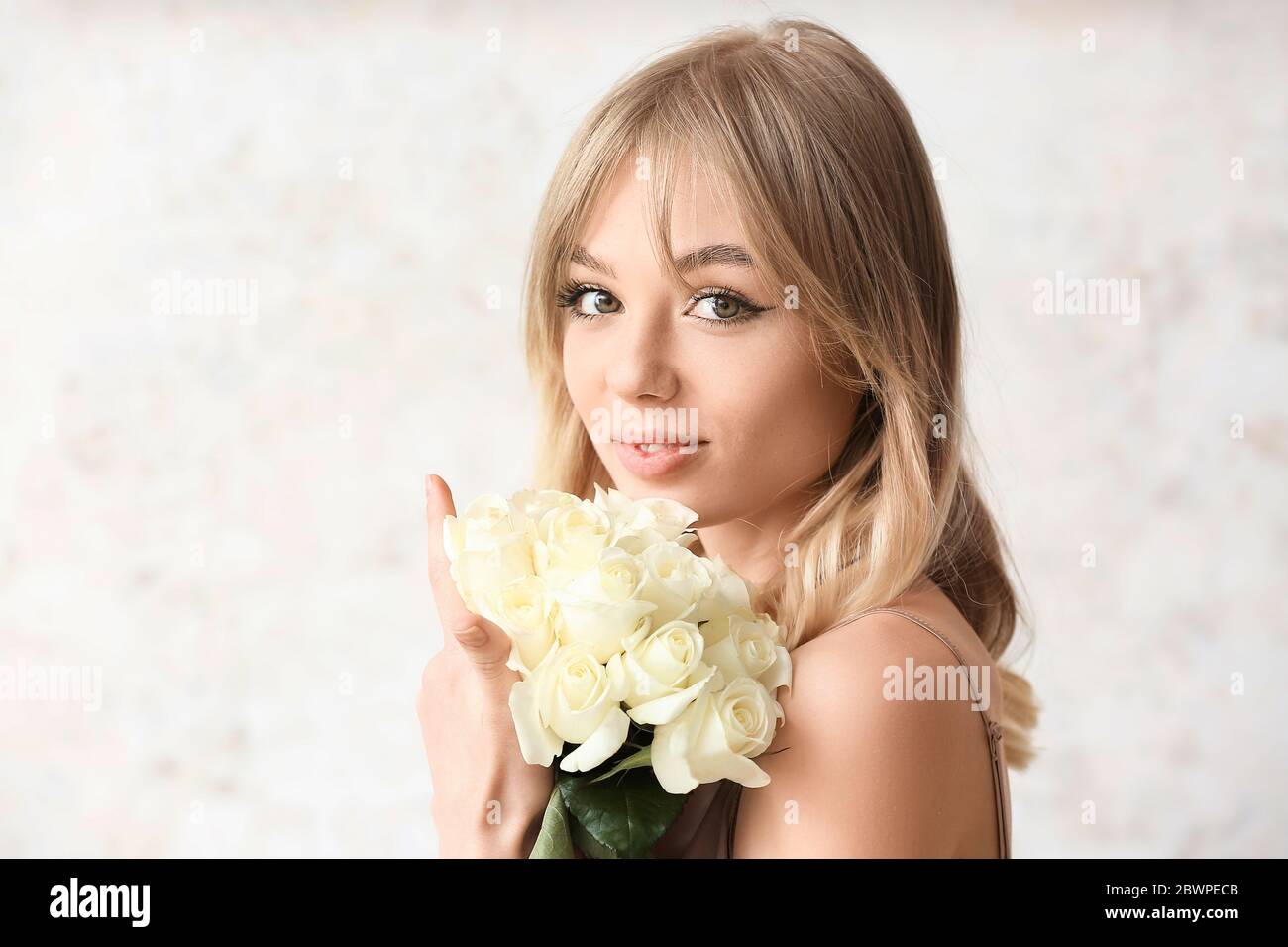 Beautiful young woman with bouquet of roses on light background Stock ...