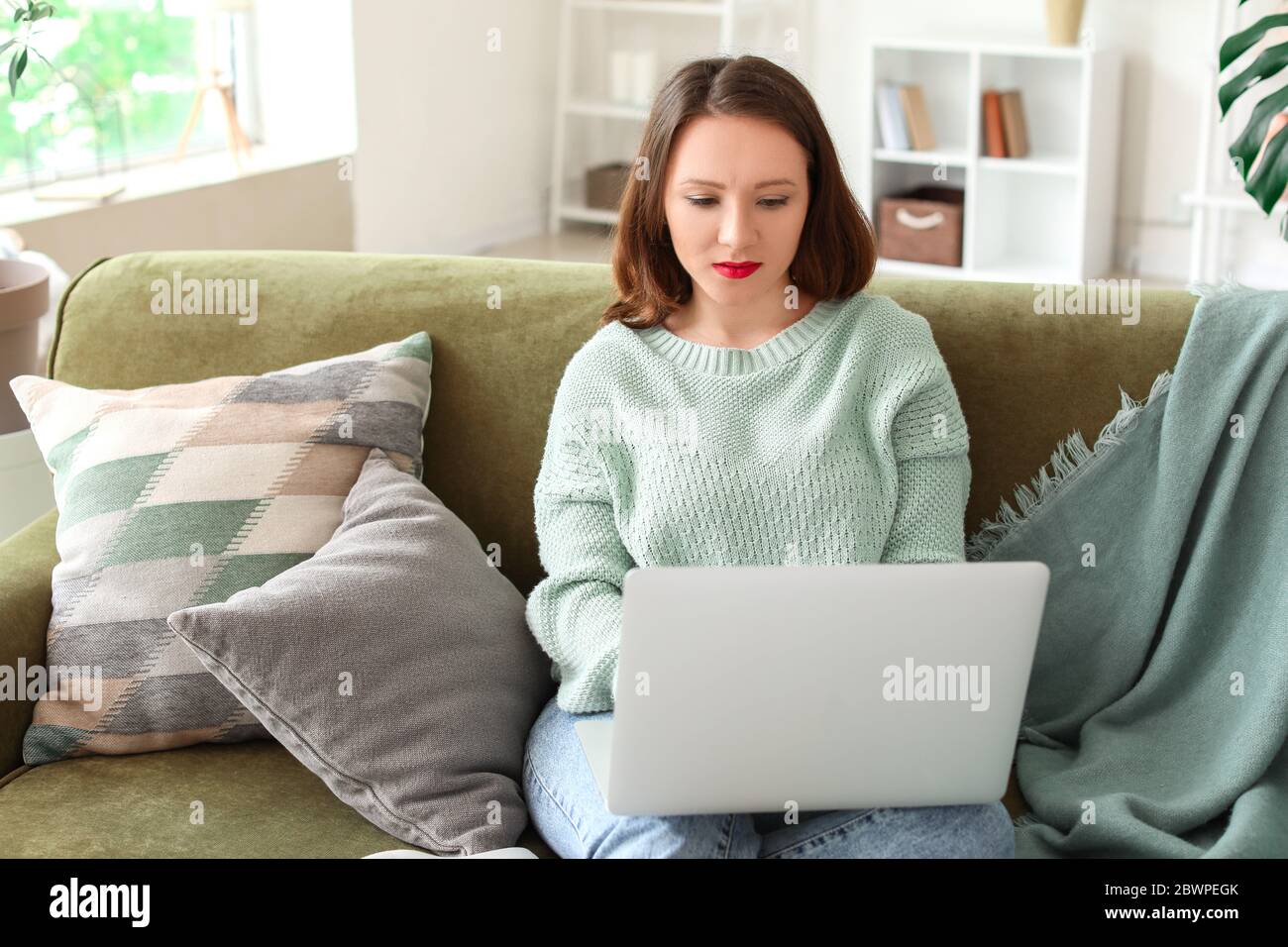 Beautiful young woman with laptop at home Stock Photo - Alamy