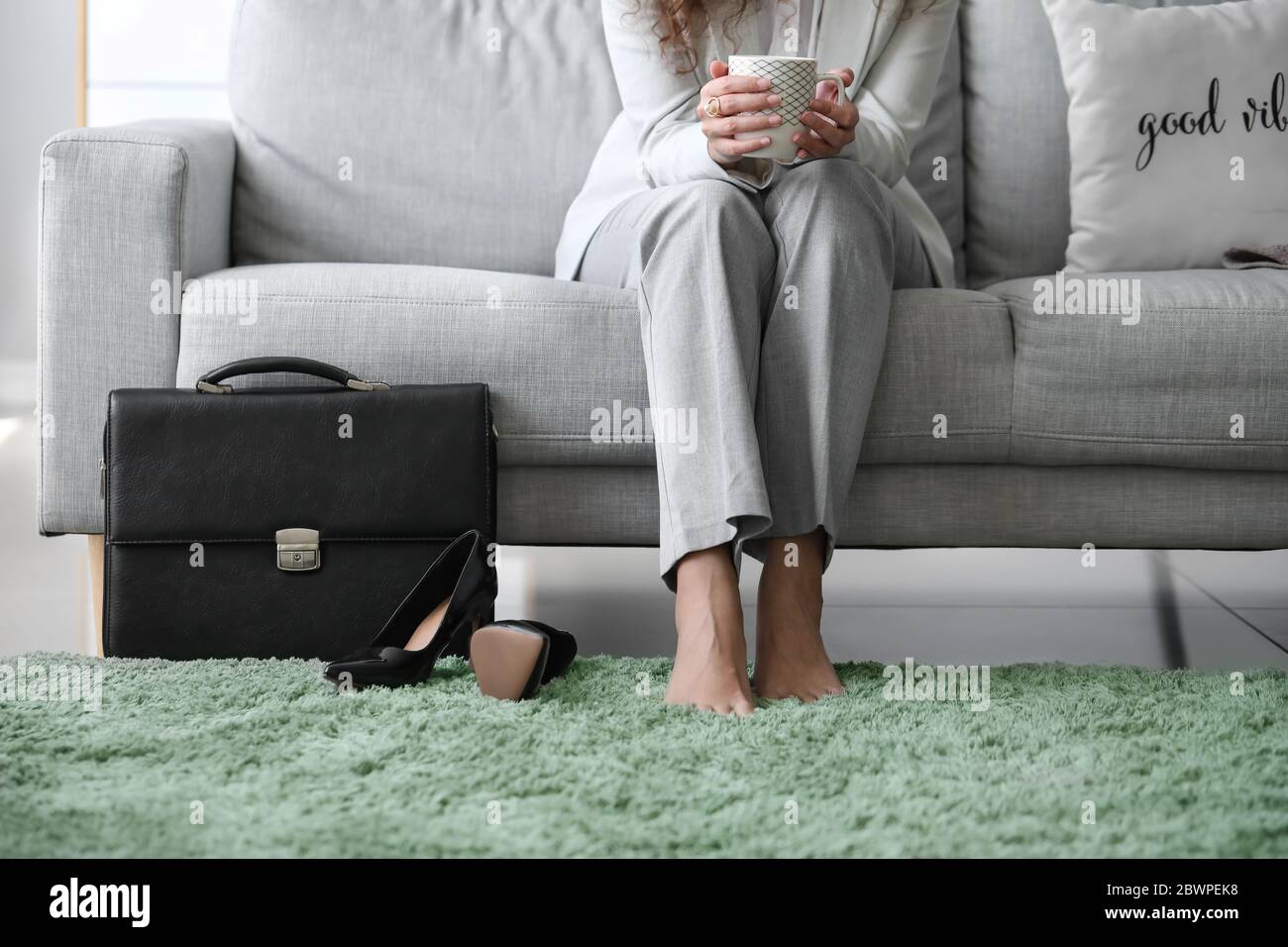 Businesswoman relaxing on sofa after work at home Stock Photo