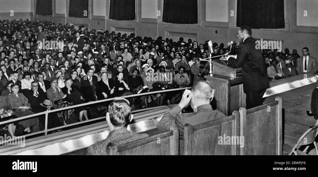 Martin Luther King, Jr. delivering a speech on 'Non-Violence and Racial Justice' to a packed crowd at Broughton High School in Raleigh, North Carolina on February 10, 1958. King was invited to Raleigh by the United Church, but spoke in the school's auditorium because the church's building was too small to accommodate the expected crowd. Stock Photo