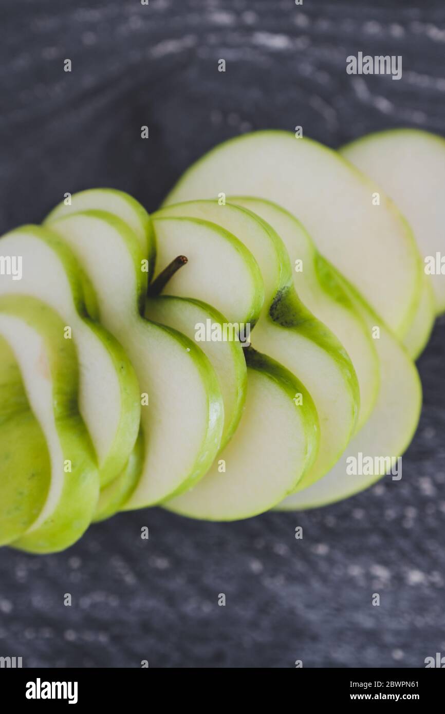 healthy plant-based food ingredients concept, green apple cut into thin  equal slices with a heart shape Stock Photo - Alamy
