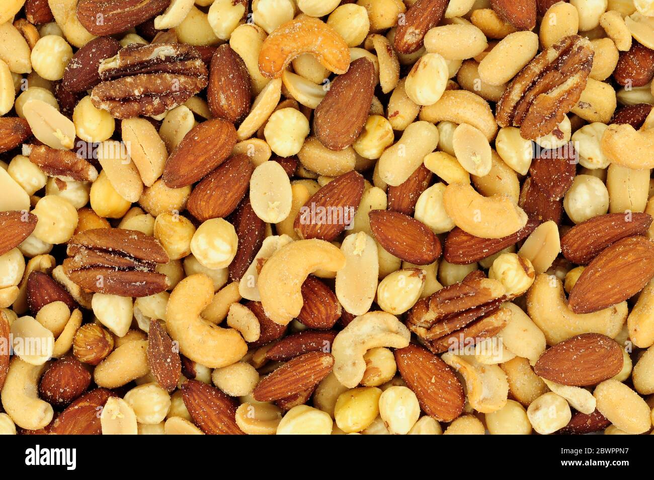 Roasted salted mixed nuts flavourful snacking background Stock Photo