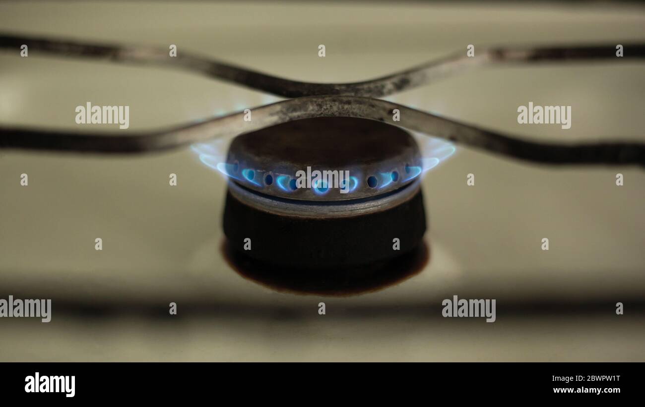 lit burner on a gas stove close-up, communal price reduction. Stock Photo