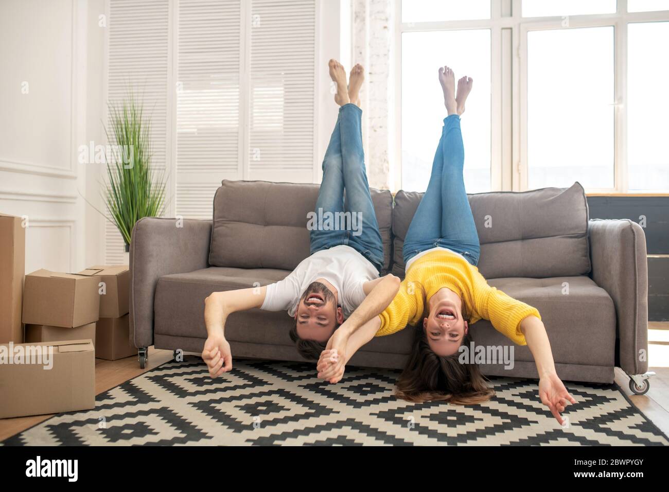 Man and girl lying on couch raising their legs up Stock Photo Alamy